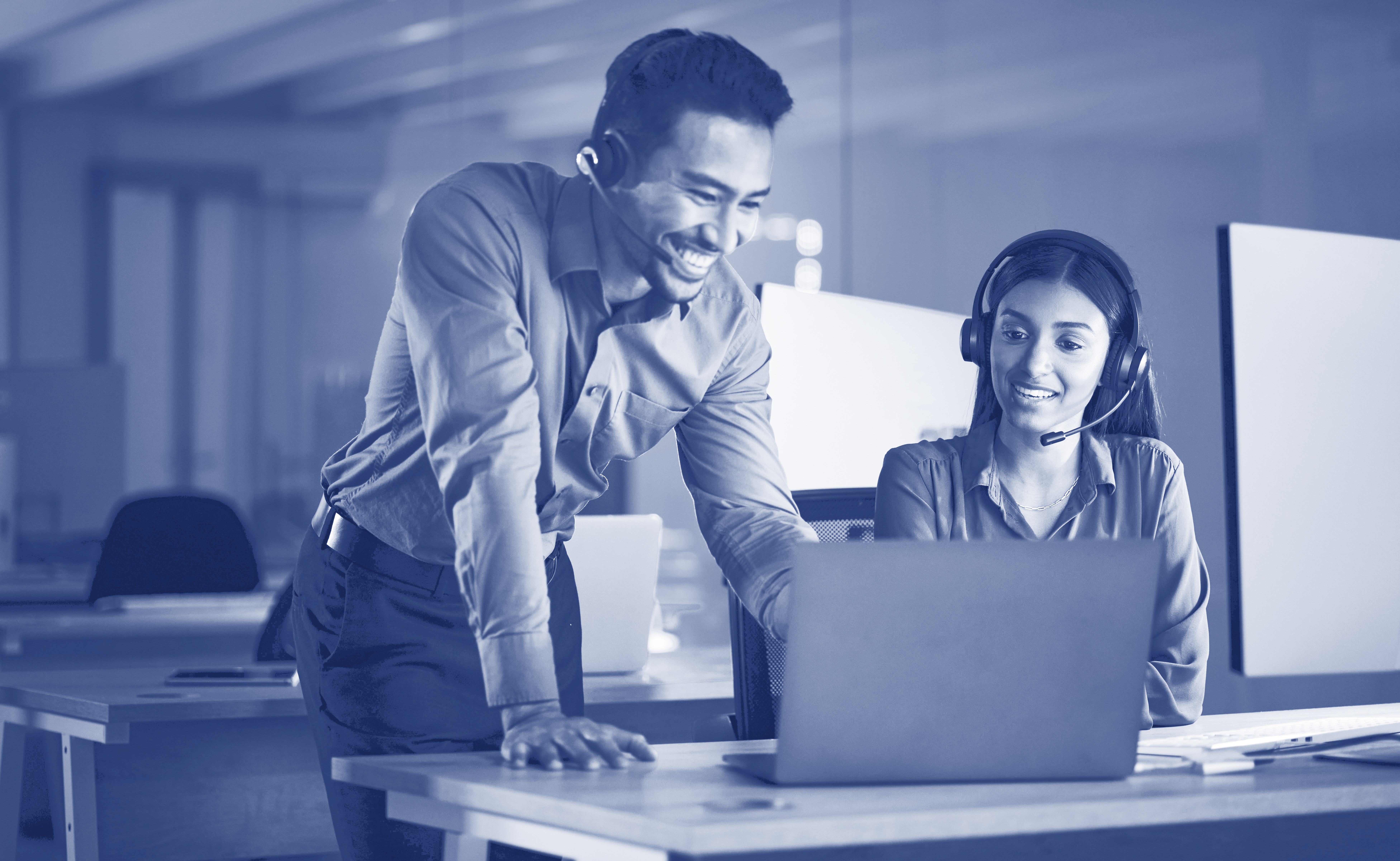 Business people, call center and coaching on laptop at night in customer service or support at the office. Happy businessman or virtual assistant working late and training woman consultant or agent